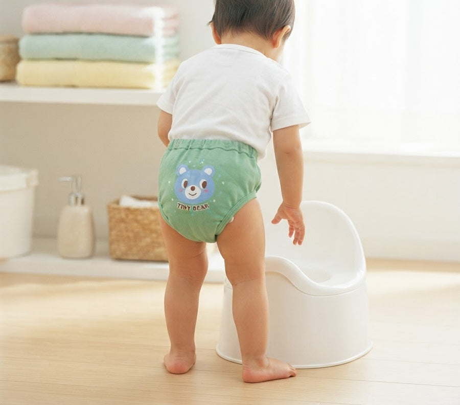 Toddler in Nestiane training underwear next to a potty